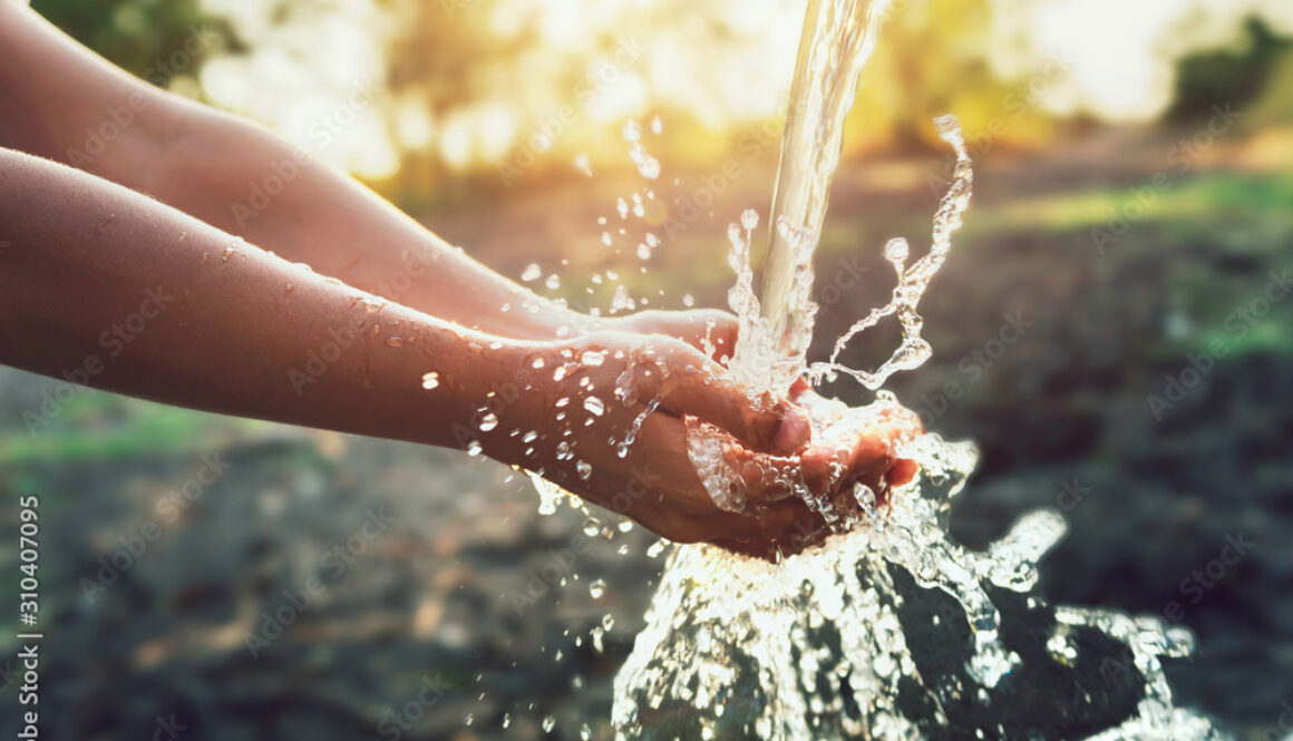 Water pouring on hand in morning ligth background