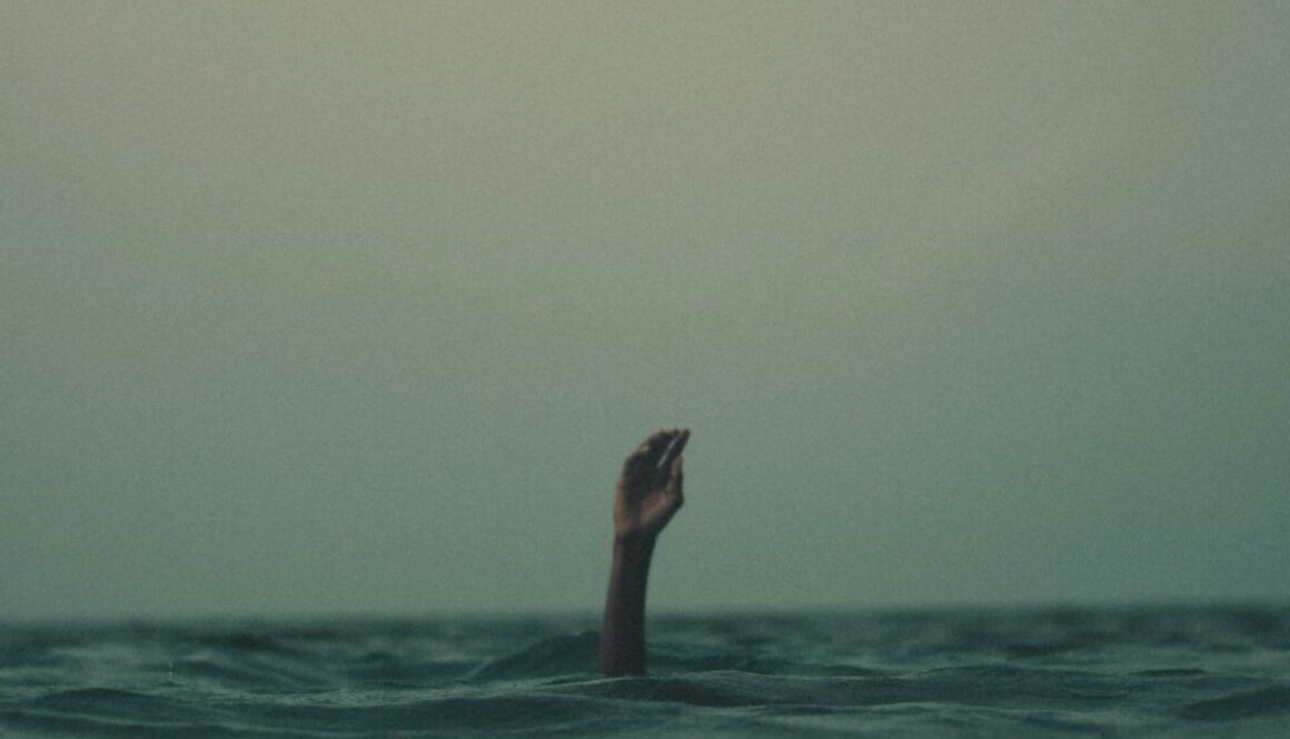 person with hand above water