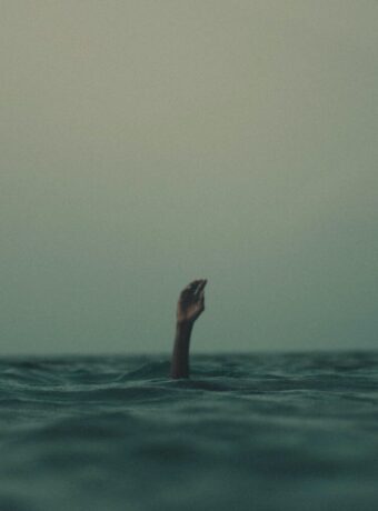 person with hand above water